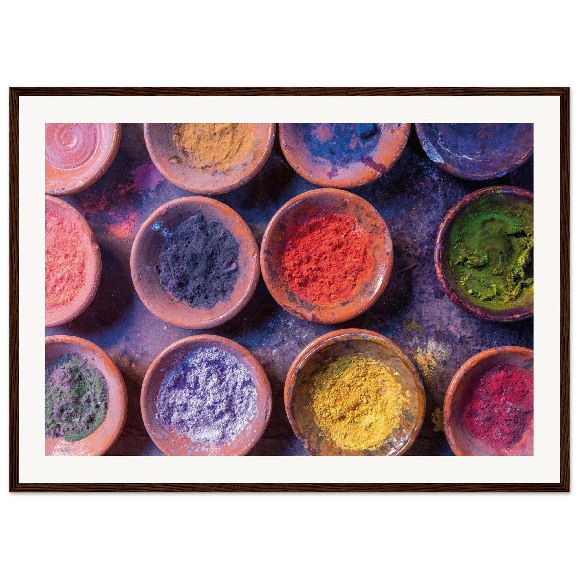 Rainbow palette of colored dusts in uniform clay bowls.

