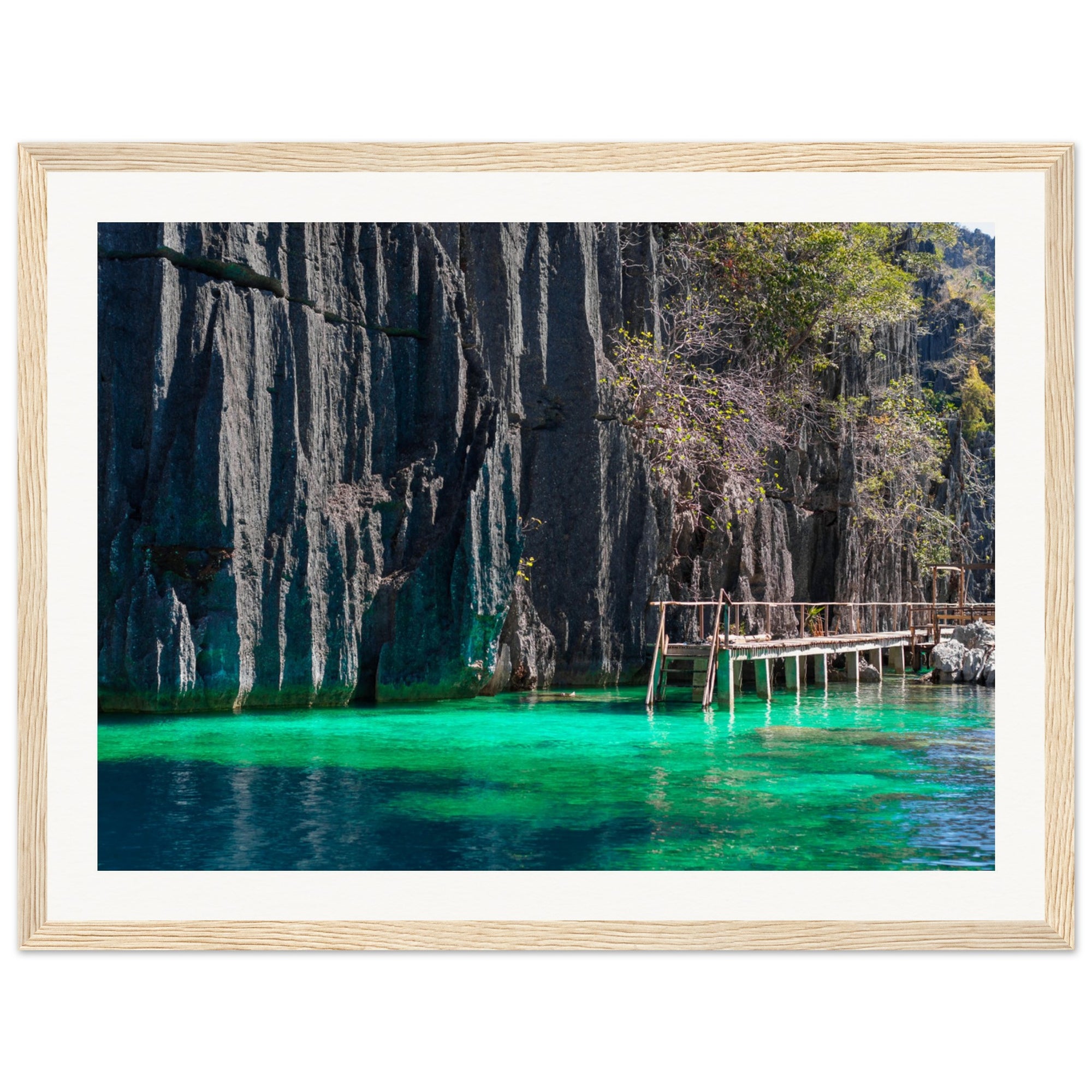 Cliffside walkway and glowing green lagoon captured in wall art.

