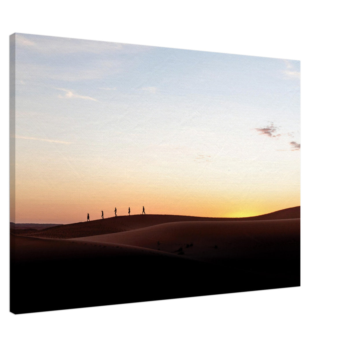 Travelers silhouetted against a warm desert sunset.

