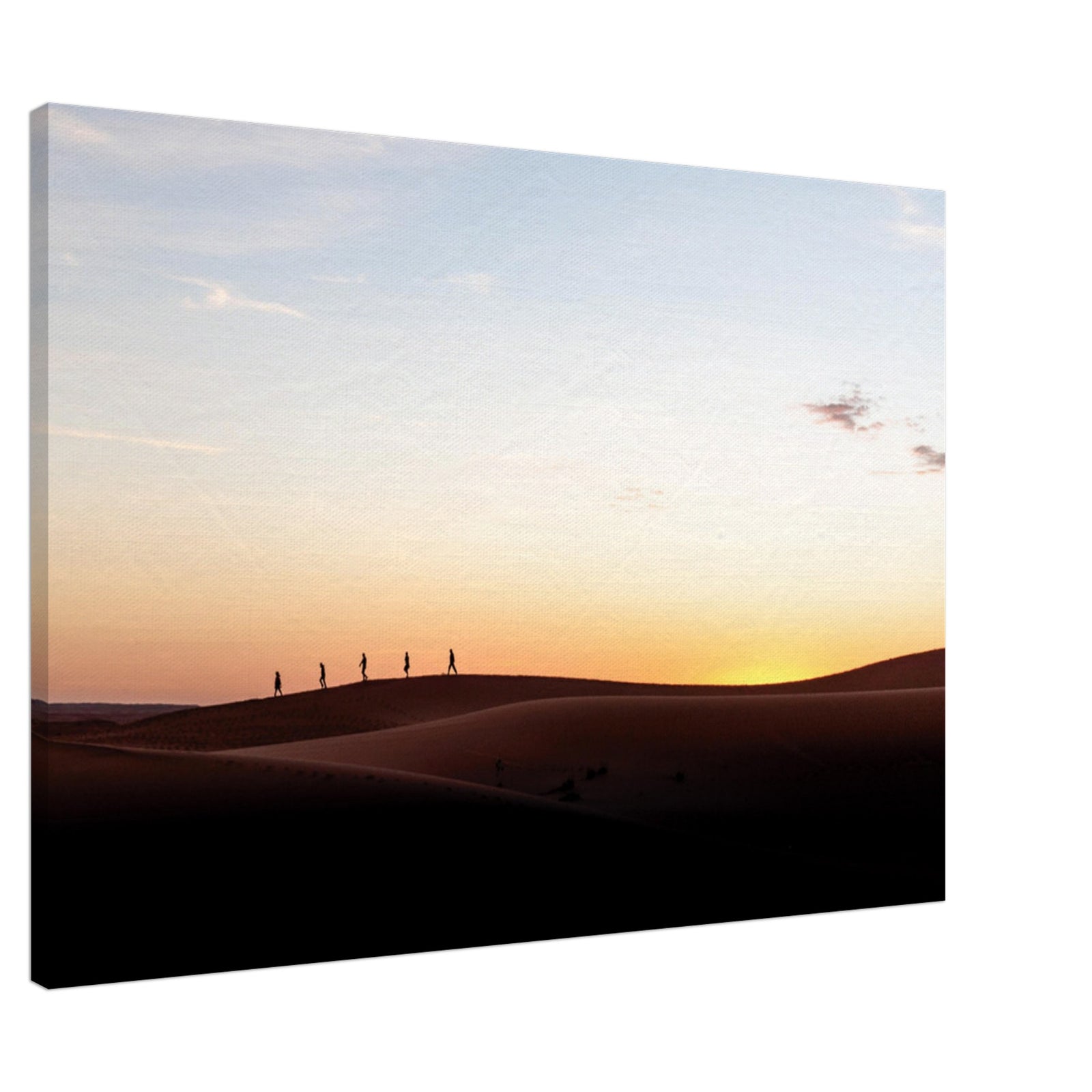 Travelers silhouetted against a warm desert sunset.

