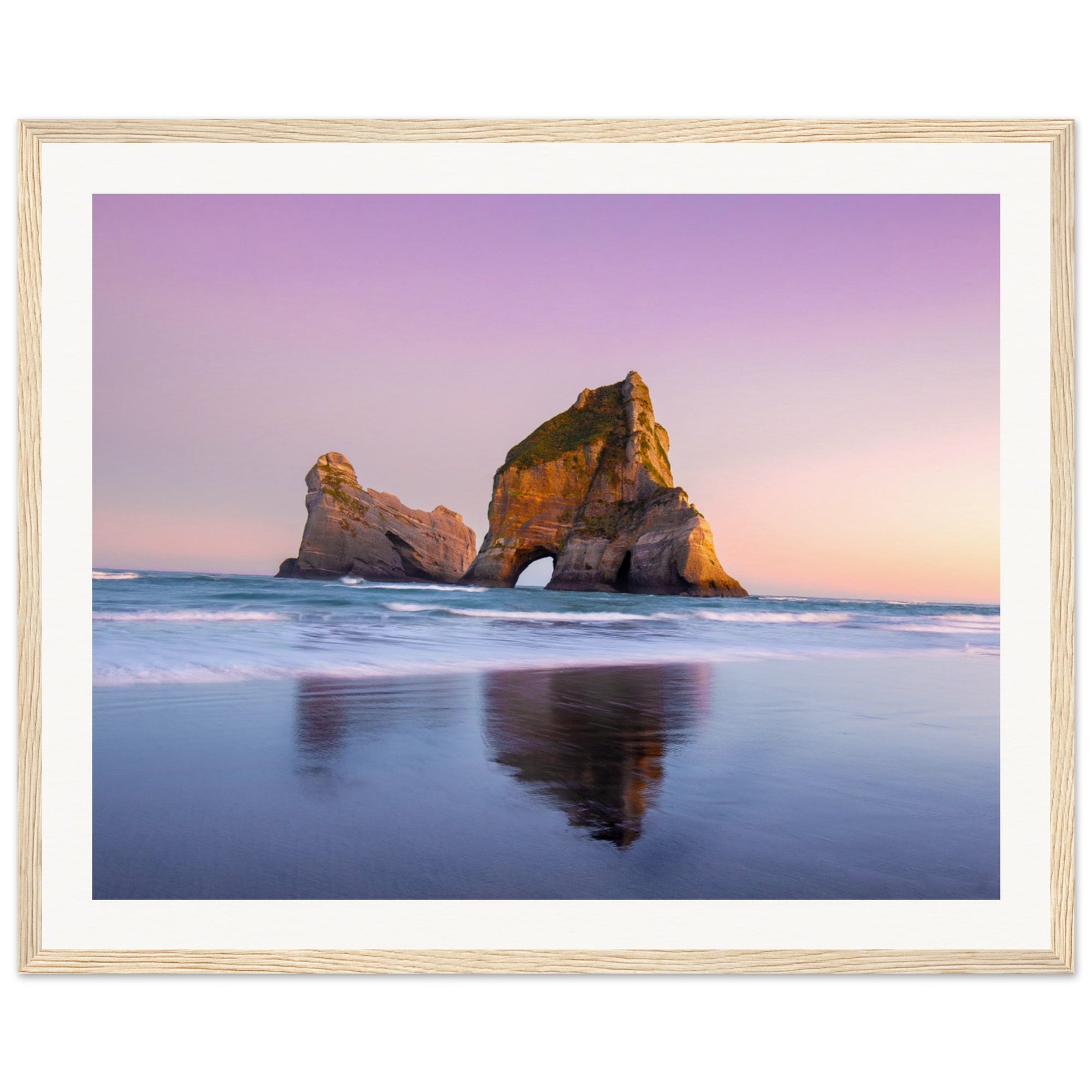 Pastel sky over calm ocean with arched rock in framed art.

