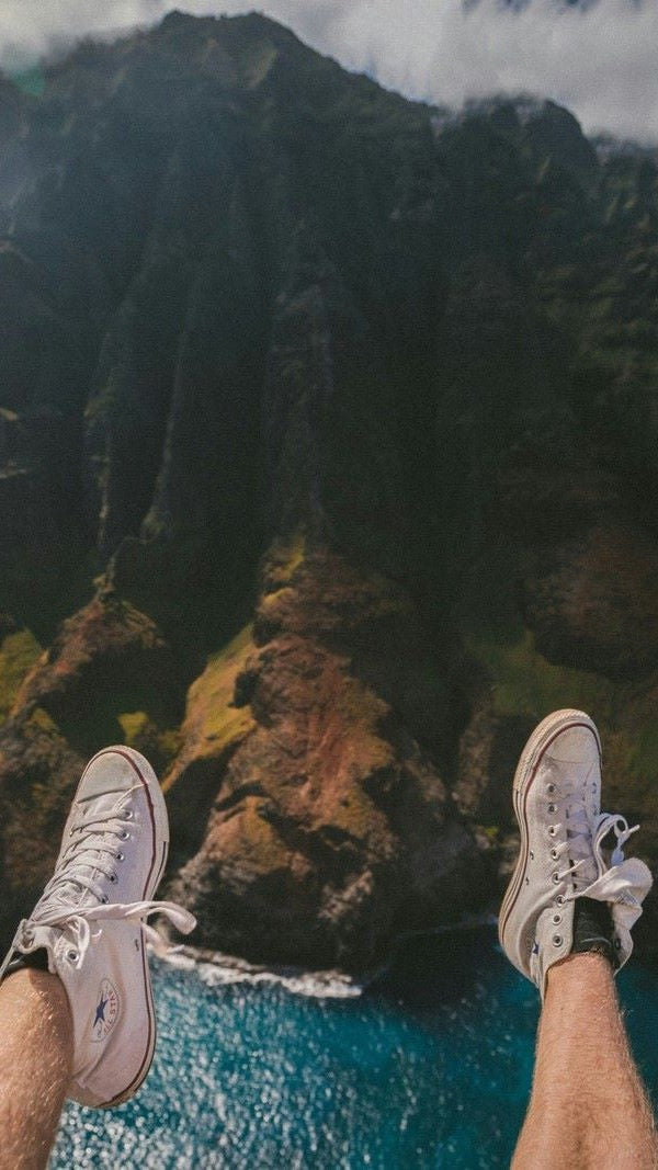 legs on edge of mountain, river below legs